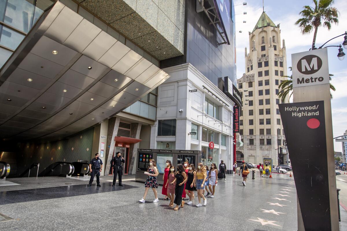 People walk past a Metro station in an urban area