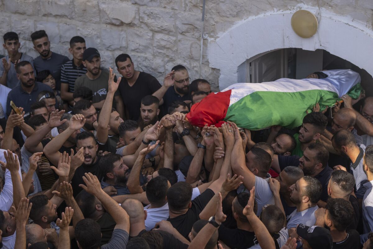 Mourners carry the body of Salah Sawafta, 58 during his funeral in the West Bank city of Tubas, Friday, Aug. 19, 2022. Israeli forces shot and killed Sawafta during an arrest raid in the occupied West Bank on Friday, according to his brother, who said he was walking home when a bullet struck him in the head as Israeli forces clashed with Palestinian youths. (AP Photo/Nasser Nasser)