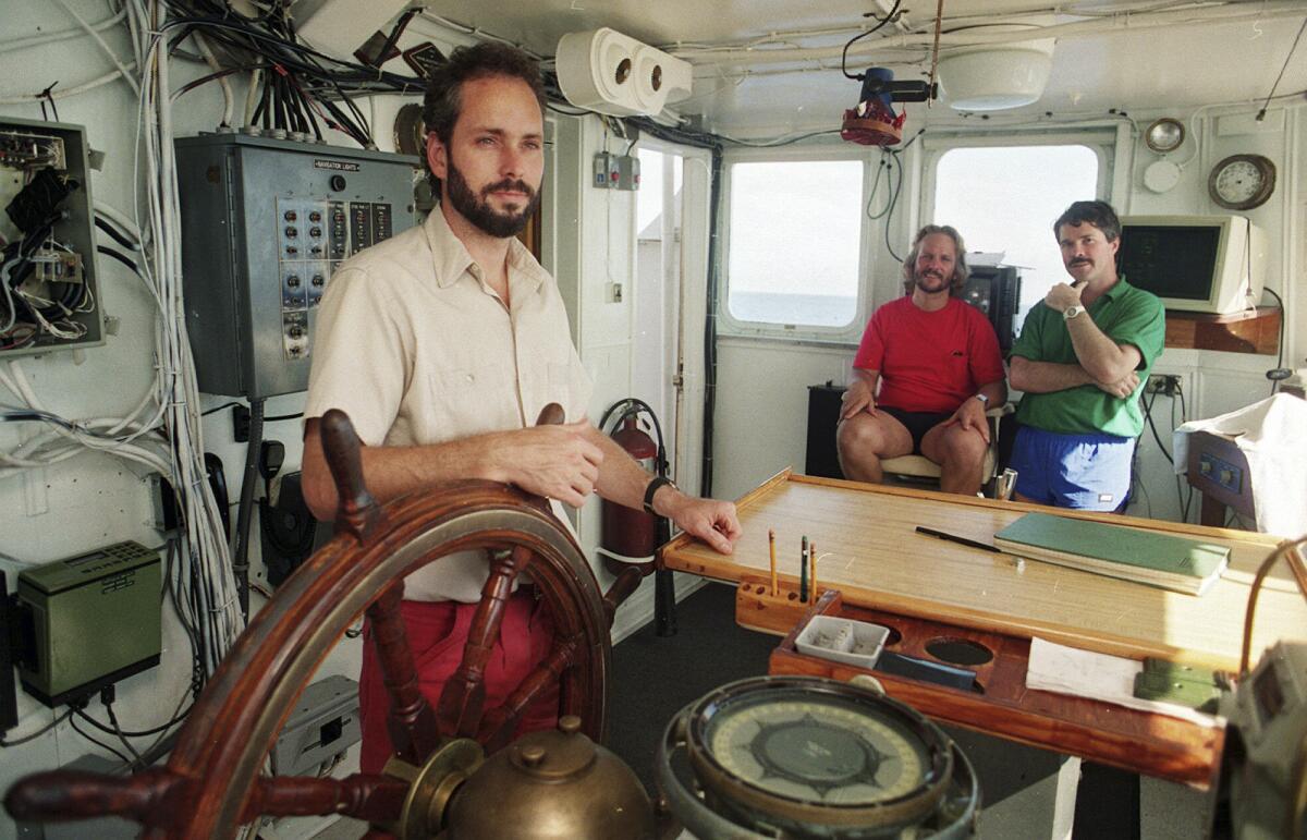 Tommy Thompson, left, stands at the helm of the Arctic Explorer. 