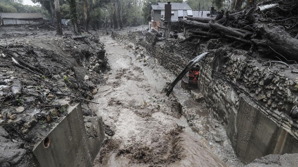 Runoff in Montecito Creek runs past homes destroyed in the January mud and debris slide.