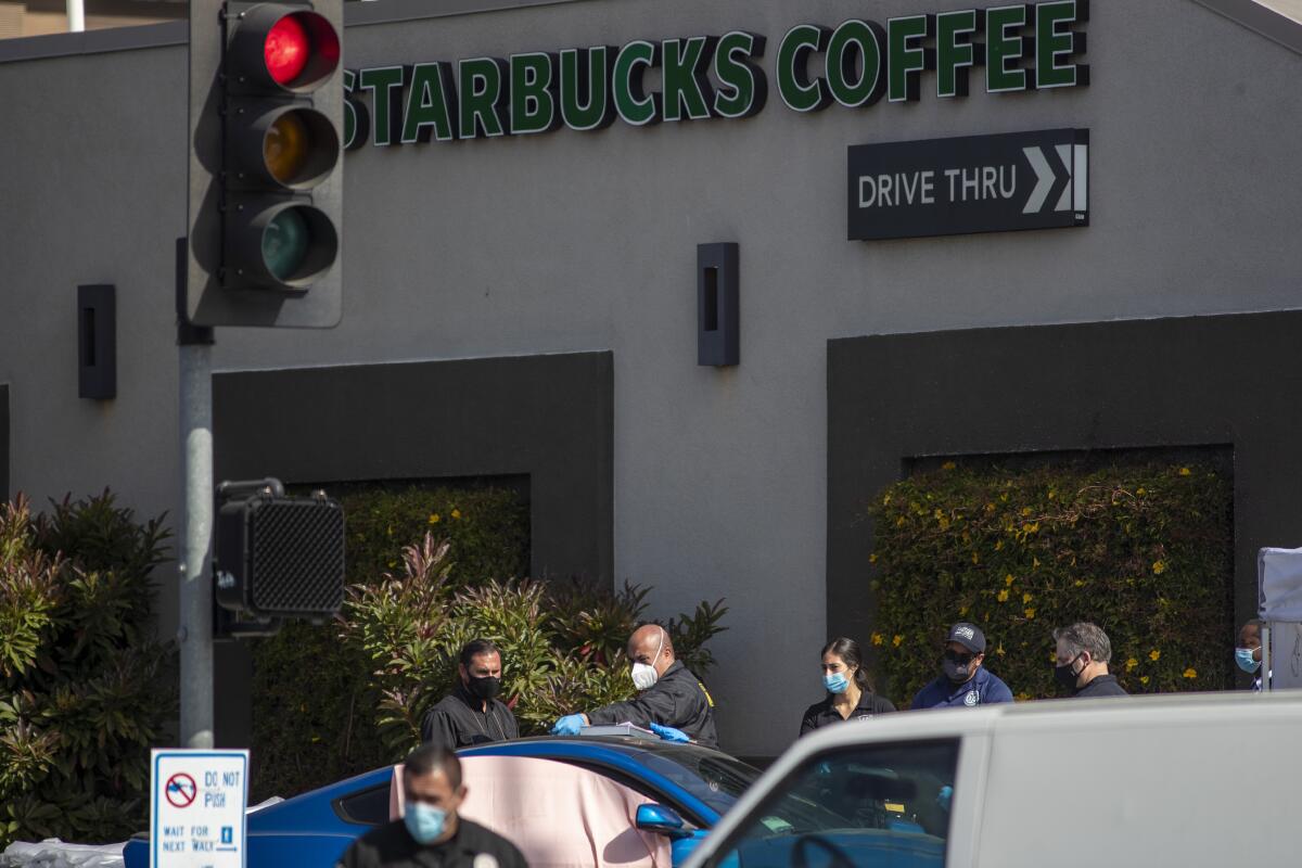 Investigators stand in front of a Starbucks where Alexis Carbajal was killed.