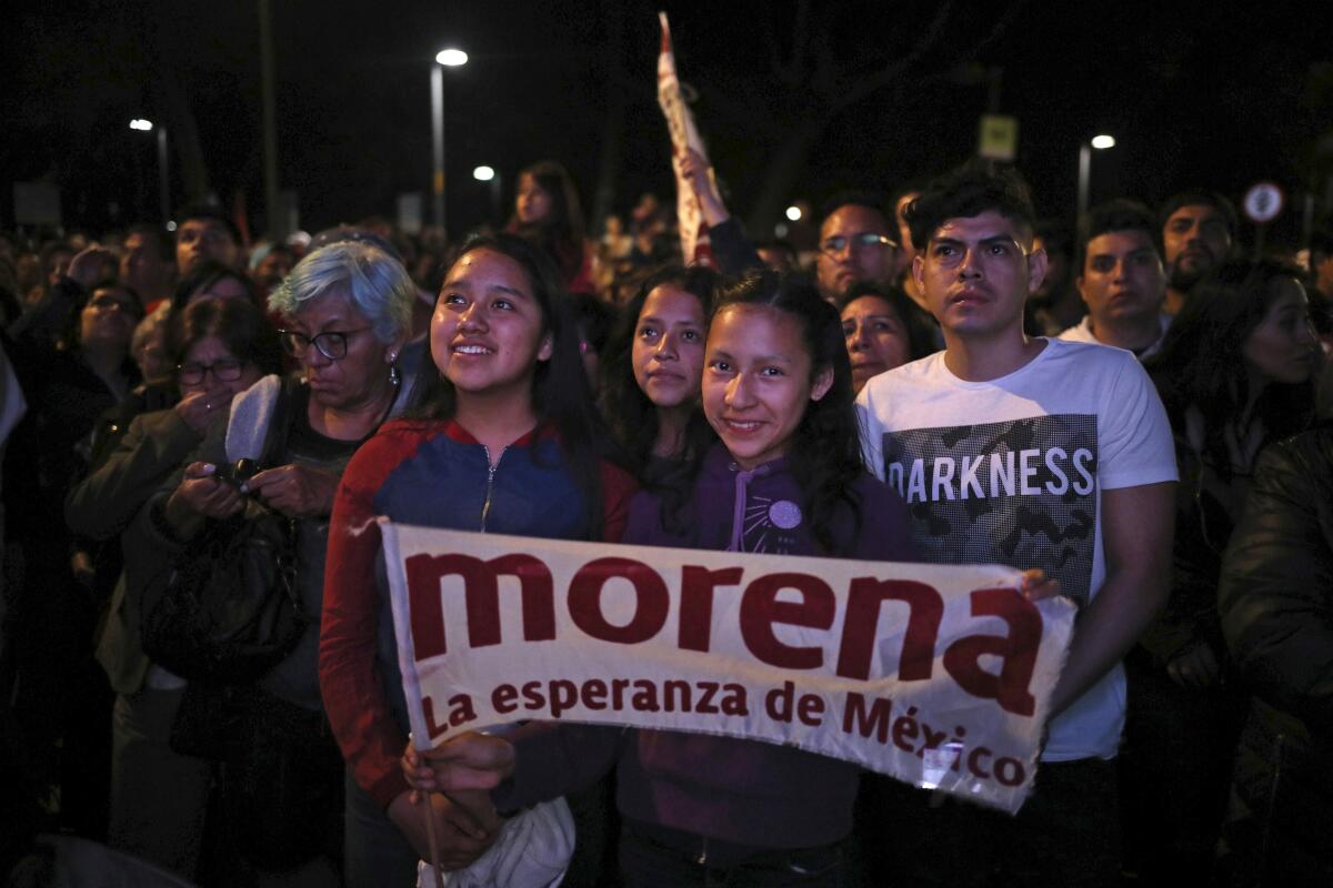 Supporters of Morena, the party of Mexican President Andrés Manuel López Obrador, holding a banner