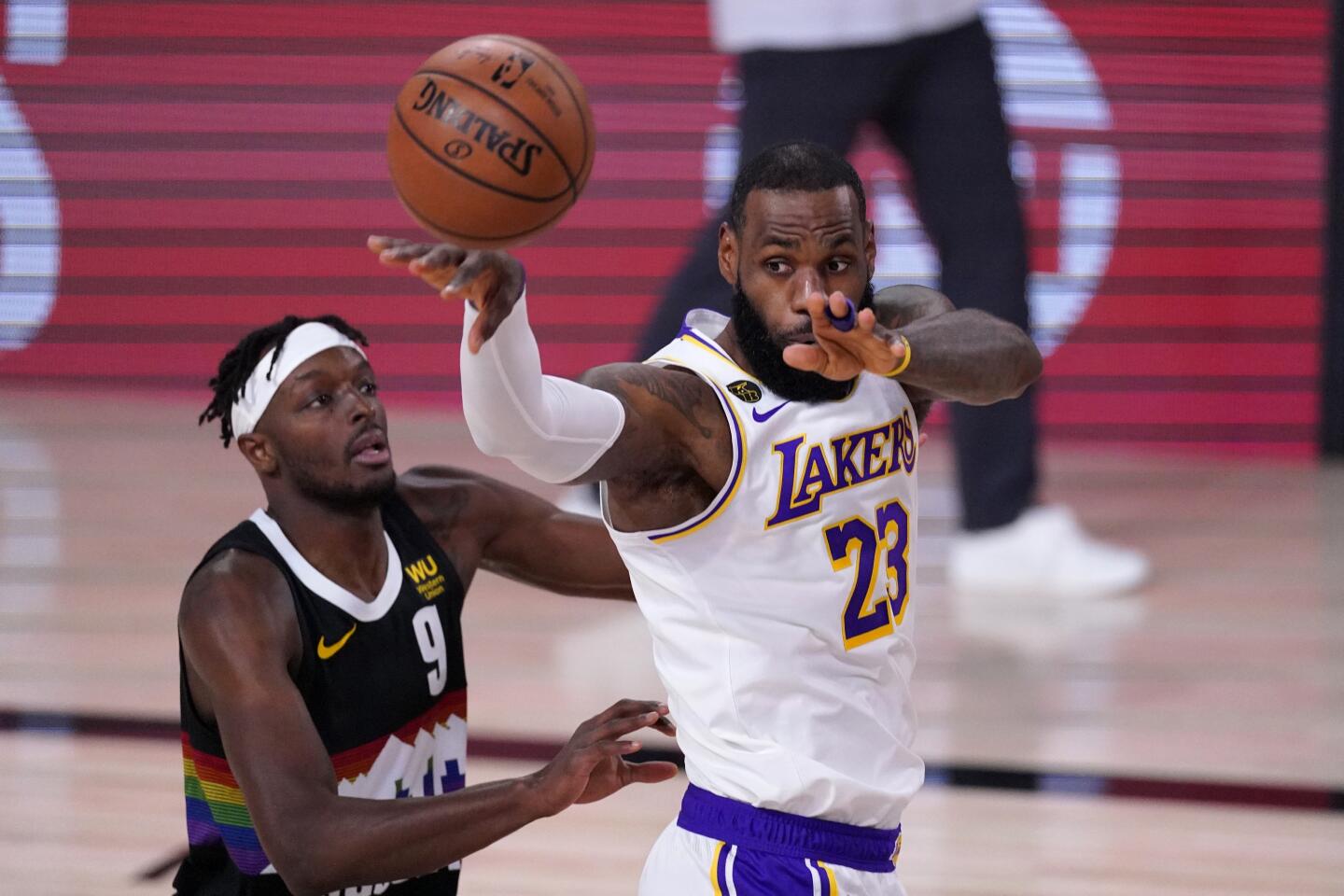 Lakers forward LeBron James, right, passes in front of Denver Nuggets forward Jerami Grant during the first half of Game 3.
