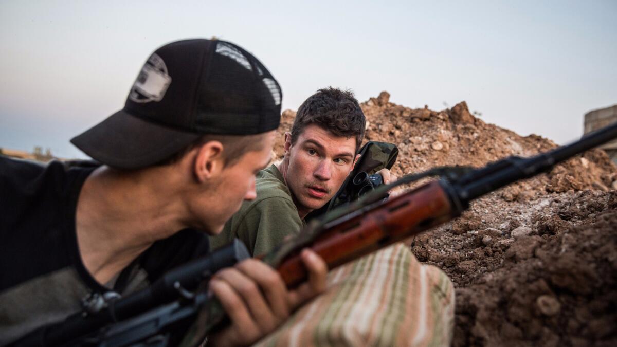 Levi Shirley, right, with Kurdish forces fighting Islamic State in Syria in 2015. A funeral for Shirley was held Saturday.
