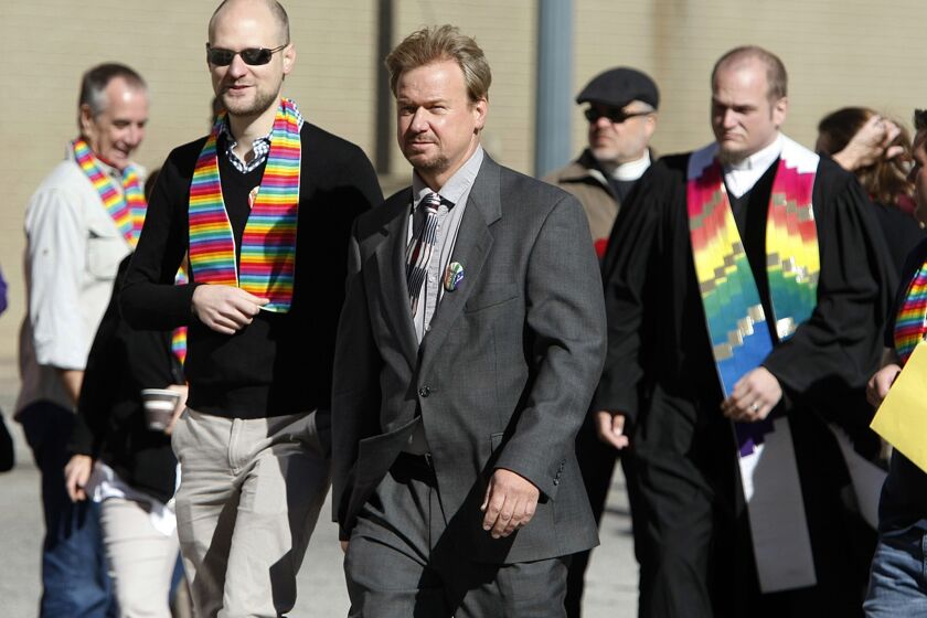 Rev. Frank Schaefer, center, and his son, Tim Schaefer, second from left, walk to a meeting of the Judicial Council of the United Methodist Church, in Memphis, Tenn.