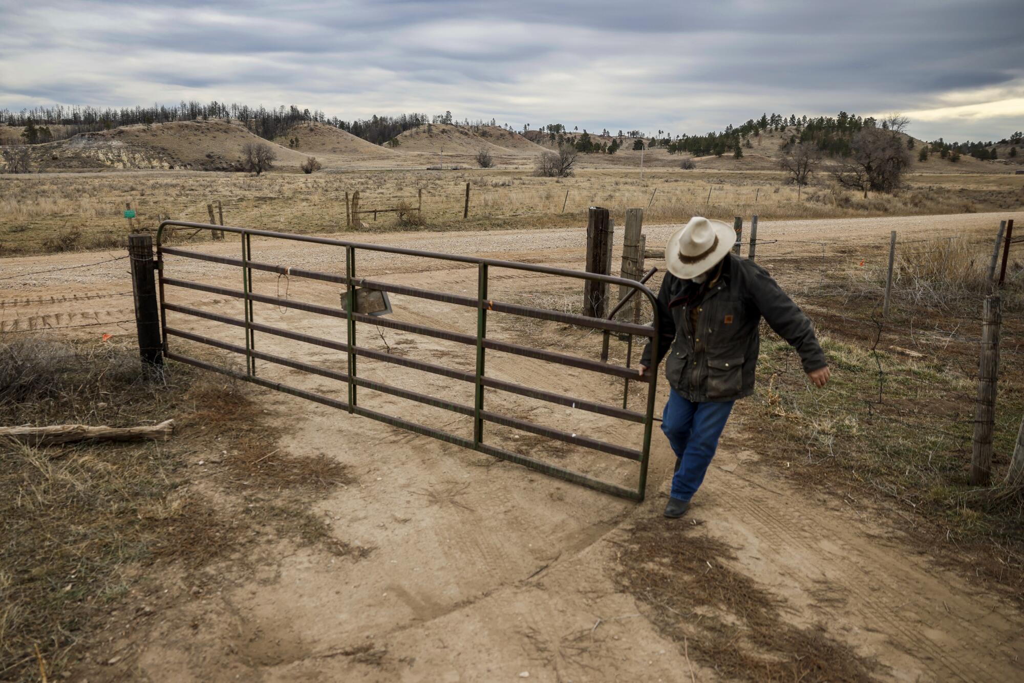 Rancher Clint McRae opens a gate on his family's land outside Colstrip.