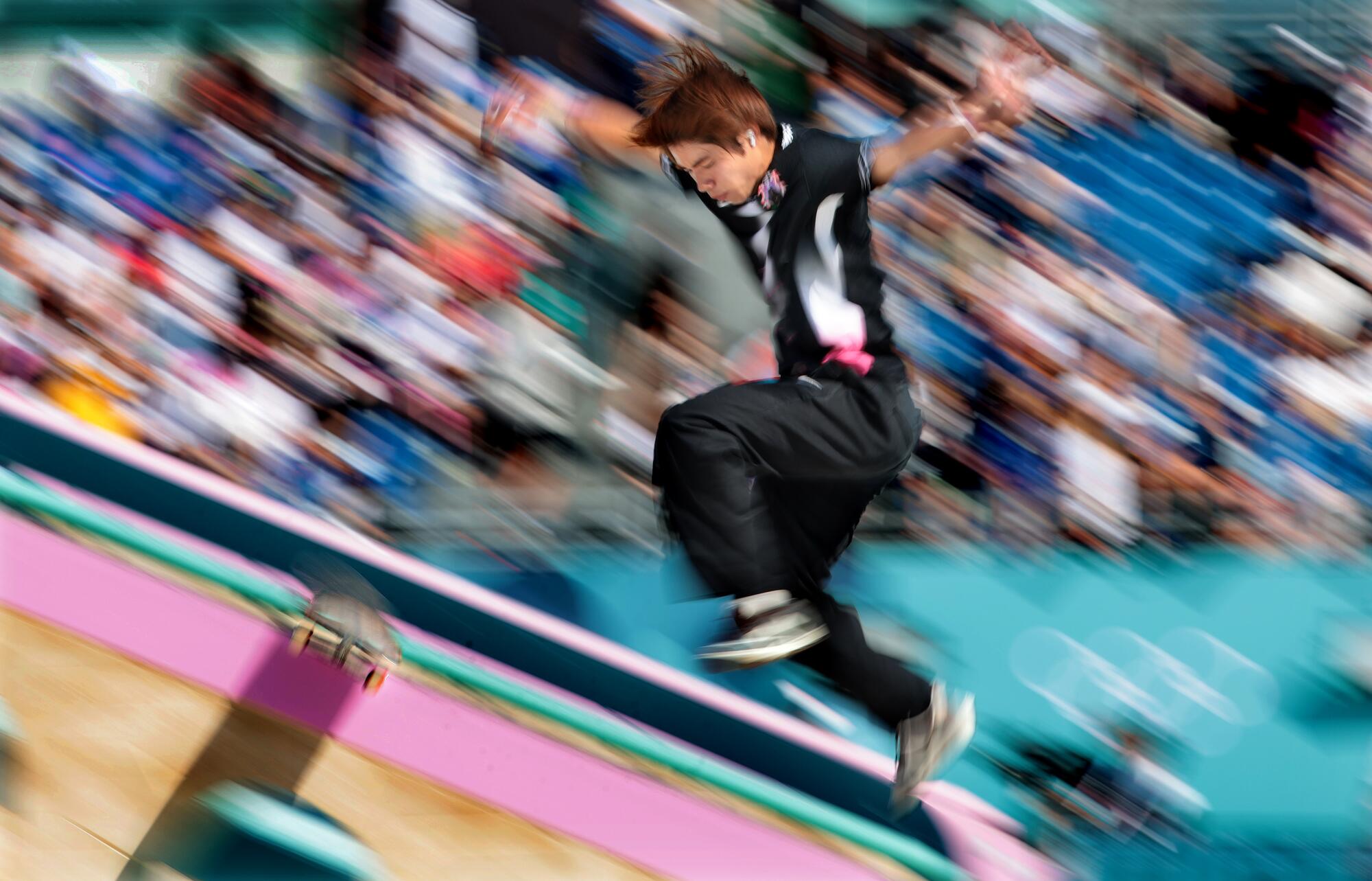 El japonés Yuto Horigome se cae de los rieles durante la primera ronda de la competencia masculina de skate.