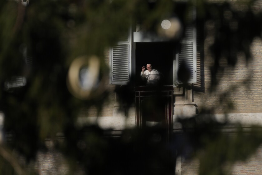 Pope Francis, framed by the Vatican Christmas tree, salutes pilgrims and faithful during the Angelus noon prayer from the window of his studio overlooking St.Peter's Square, at the Vatican, Sunday, Dec. 12, 2021. (AP Photo/Alessandra Tarantino)