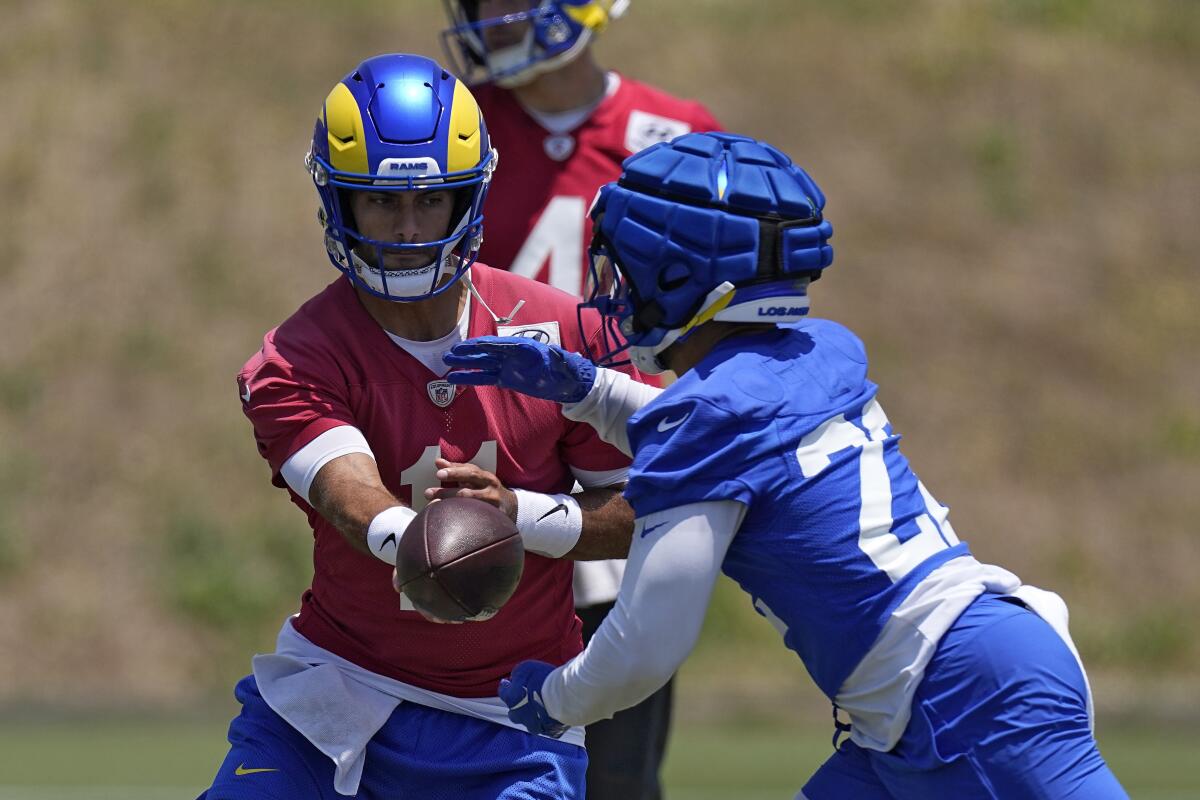 Rams rookie running back Blake Corum, right, takes a handoff from quarterback Jimmy Garoppolo during a workout Tuesday.