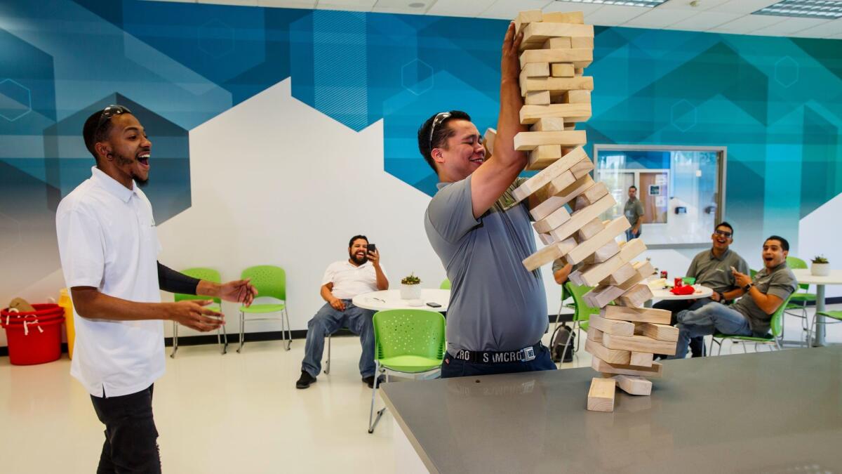 Derik Stone and Manny Almanza play giant Jenga on their lunch break. Proterra gives them 45 minutes. (Marcus Yam / Los Angeles Times)