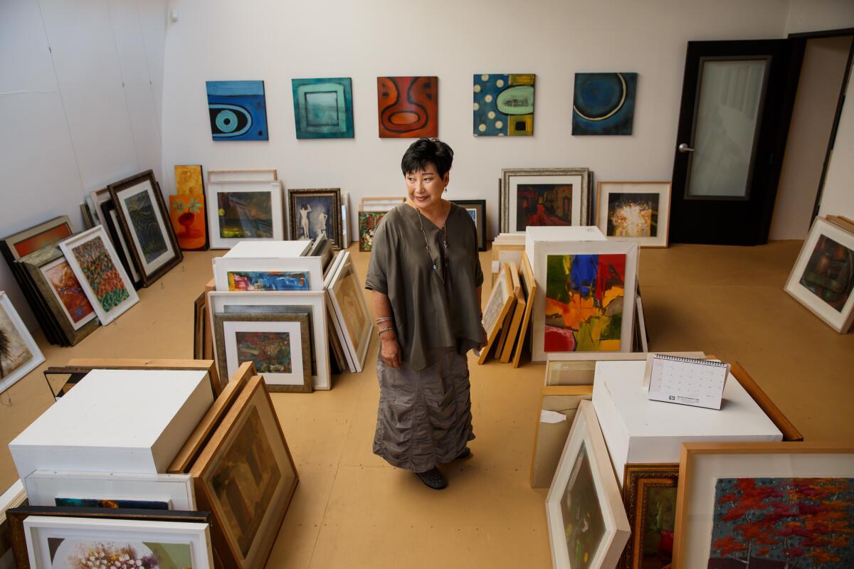 Eunice Kim, standing in a second-floor back room of the Crenshaw Boulevard building, has invited a photo gallery to take up temporary residence. An art dealer also has moved a collection there.