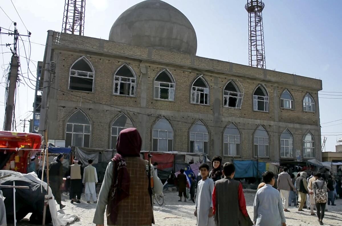 En esta imagen tomada de un video, un combatiente talibán hace guardia en el exterior de una mezquita
