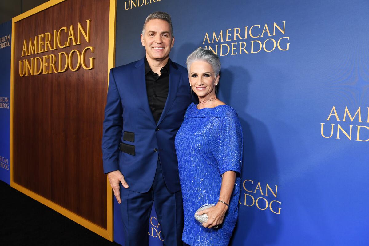 A man and a woman pose at a movie premiere.