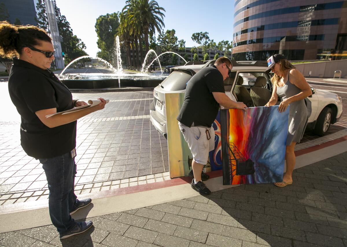 Tracy Habiger, left, and Kevin Stoddart check in Jennifer Bloomfield's art Thursday at Segerstrom's Samueli Theater.