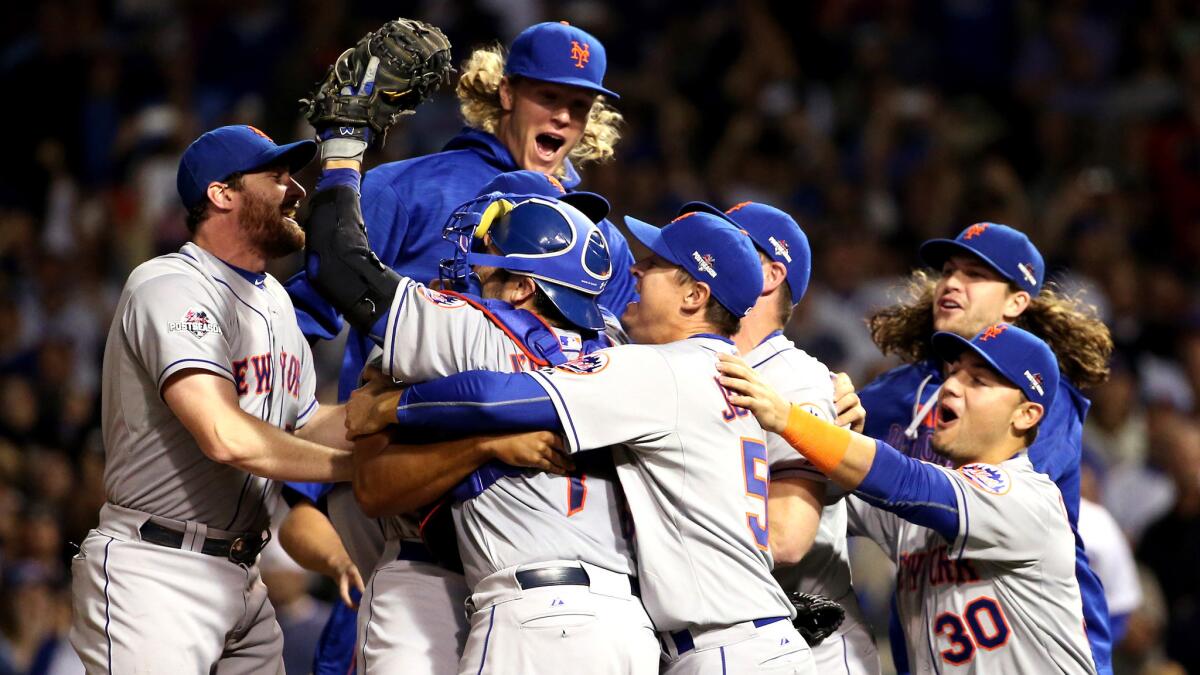Second baseman Daniel Murphy, left, and pitcher Noah Syndergaard, leaping, join their Mets teammates to celebrate winning the NLCS over the Cubs on Wednesday night in Chicago.