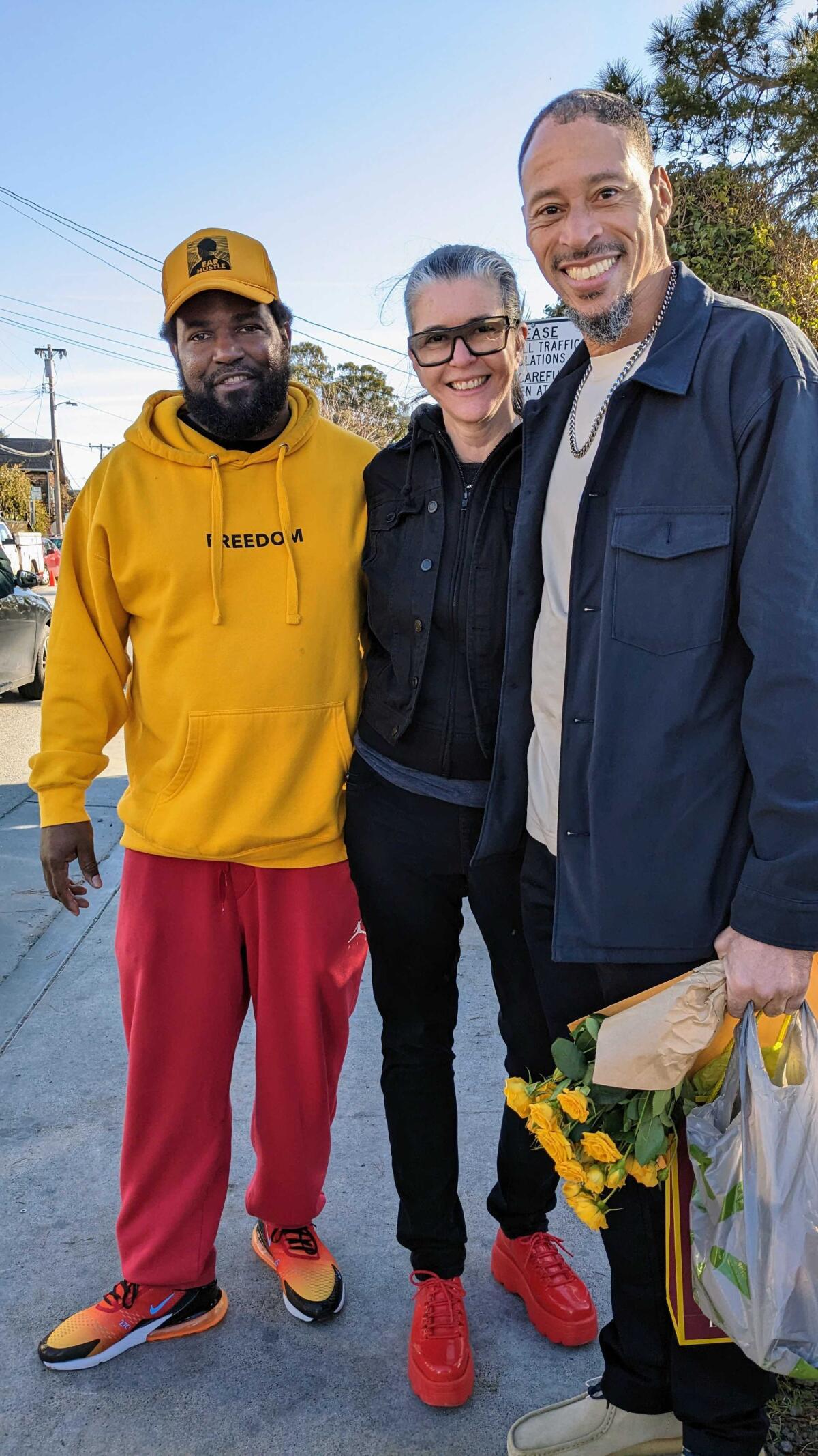 Three people standing outside a prison in California