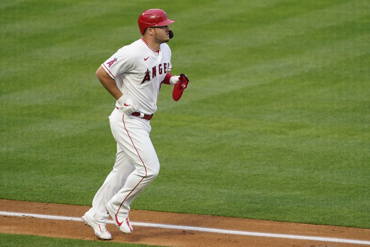 Los Angeles Angels' Mike Trout (27) is walked by Cleveland Indians starting pitcher Sam Hentges during the first inning of a baseball game Monday, May 17, 2021, in Los Angeles. (AP Photo/Ashley Landis)