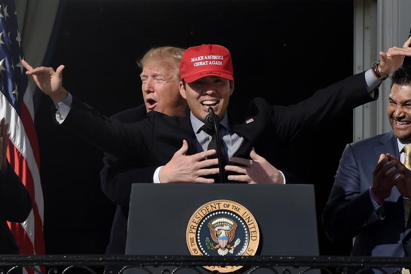 US President Donald Trump reacts as player Kurt Suzuki wears a "Make America Great Again" baseball hat during a ceremony to welcome the 2019 World Series Champions, the Washington Nationals on the South Lawn of the White House in Washington, DC, November 04, 2019. (Photo by Olivier Douliery / AFP) (Photo by OLIVIER DOULIERY/AFP via Getty Images)