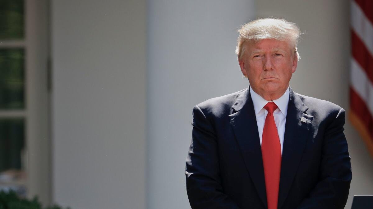 President Trump stands next to the podium after speaking about the U.S. role in the Paris climate change accord, Thursday in the Rose Garden of the White House.