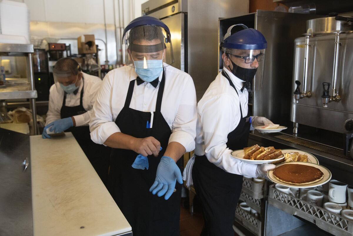 Waiters with breakfast plates at the Original Pantry in downtown Los Angeles.