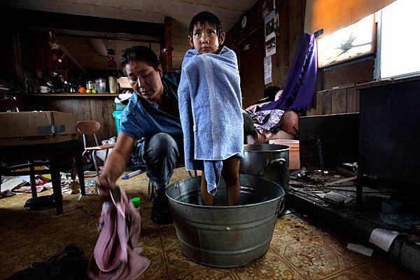 Thomasina Nez gives 4-year-old Bobbi a bath in their trailer, which has no running water: Nez hauls the water from 30 miles away and warms it on a wood stove. She bathes the smallest of her children first, then adds water and bathes the next in line until everyone is clean.