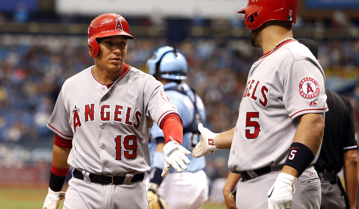 Angels left fielder Efren Navarro (19) is congratulated by first baseman Albert Pujols (5) after scoring against the Rays on a single by Mike Trout in the sixth inning Sunday afternoon.