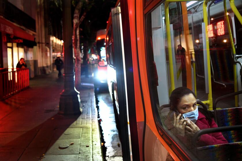 LOS ANGELES, CALIFORNIA MARCH 26, 2020-A passenger wears a mask on a Merto bus during a coronavirus outbreak in Downtown Los Angeles. (Wally Skalij/Los Angeles Times)