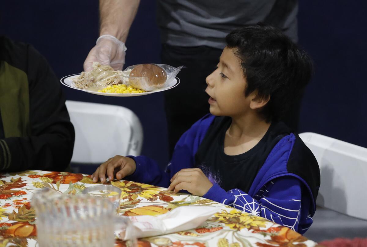 A youngster is served a traditional Thanksgiving meal at the Santa Ana Boys & Girls Club on Tuesday.