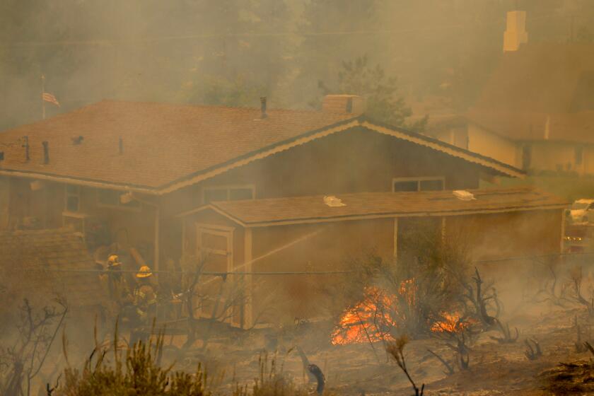 Wrightwood, CA - September 11: San Bernardino County firefighters work to save a home in Wrightwood as they battle the Bridge Fire amid high temperatures in Wrightwood Wednesday, Sept. 11, 2024. (Allen J. Schaben / Los Angeles Times)