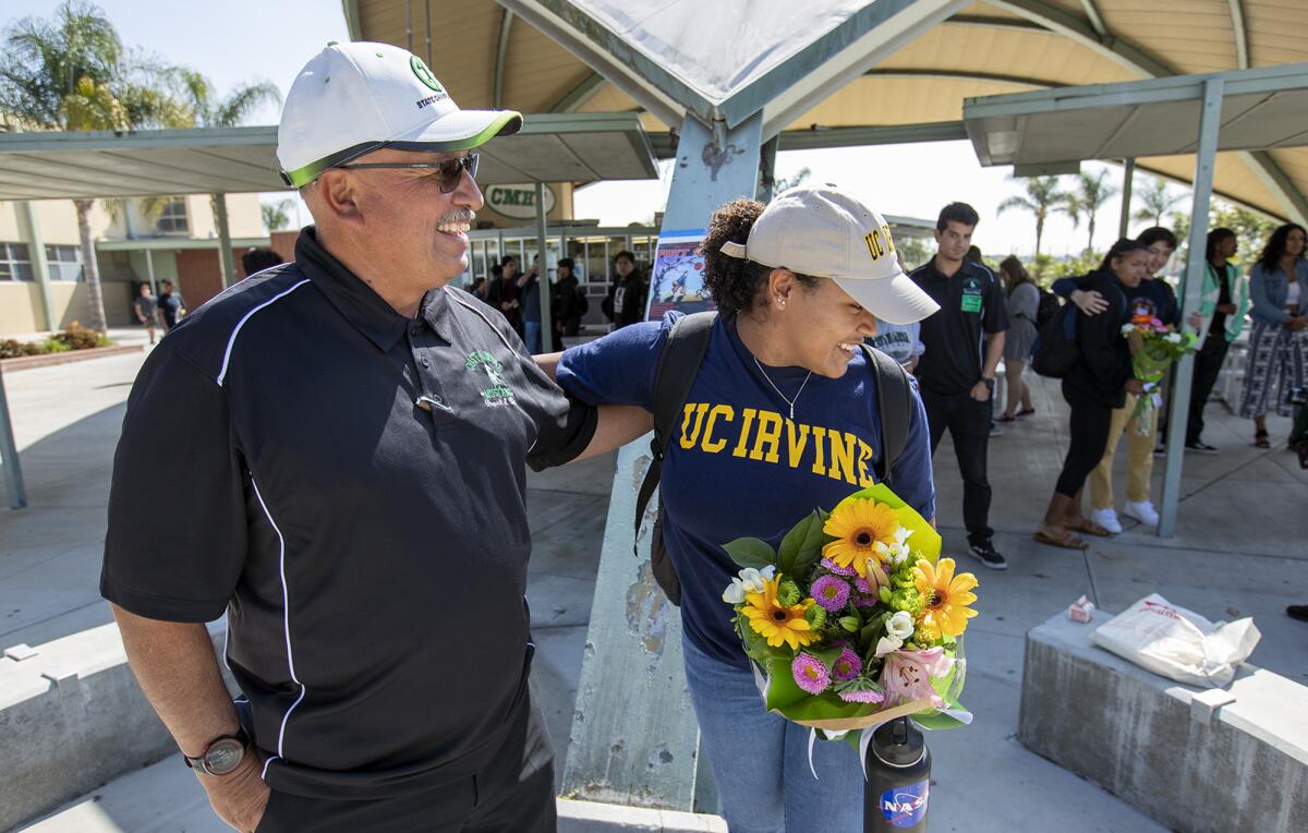 Costa Mesa coach Steve Moreno, left, hugs Tayla Crenshaw during a signing day ceremony on April 25, 2018.