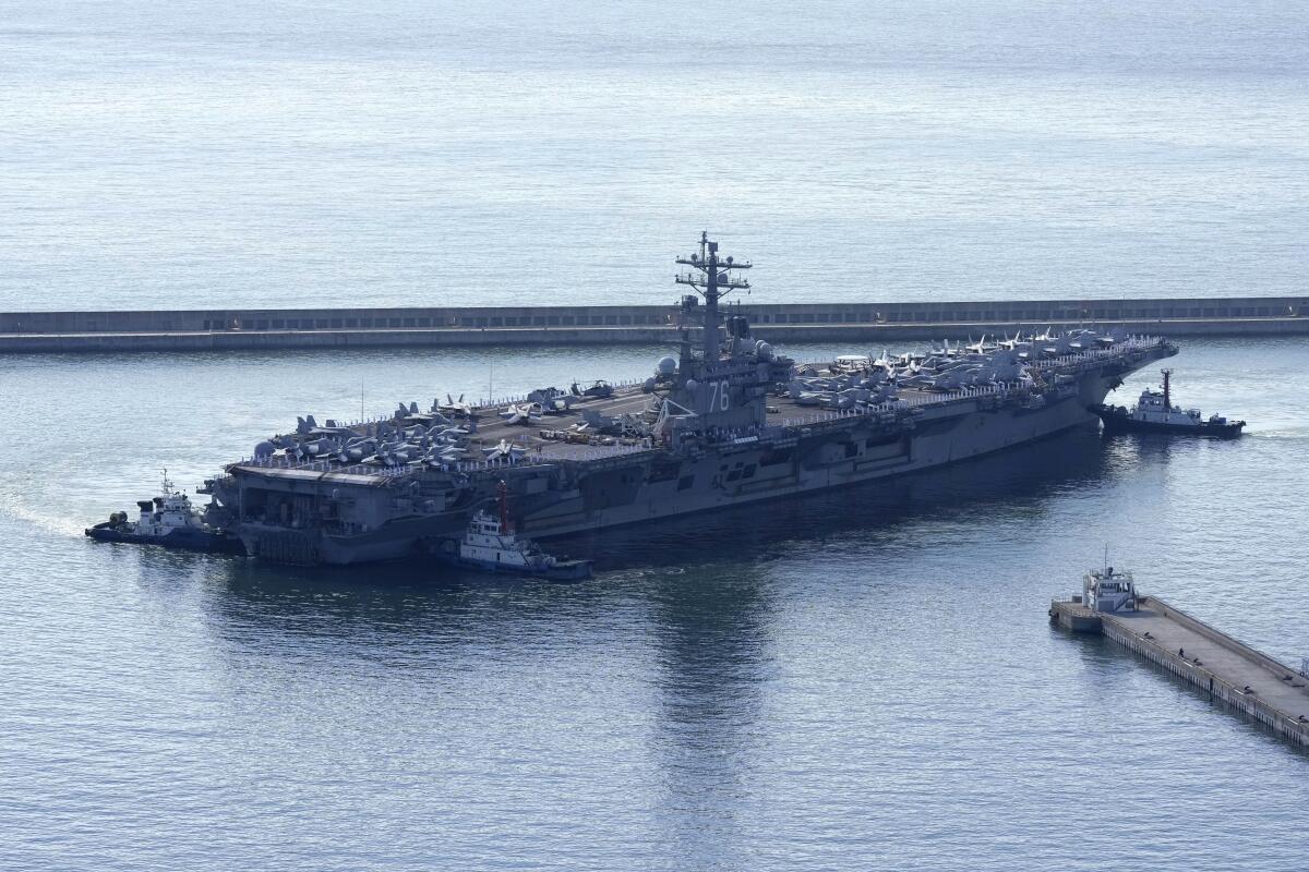 An aircraft carrier sits in a body of water.