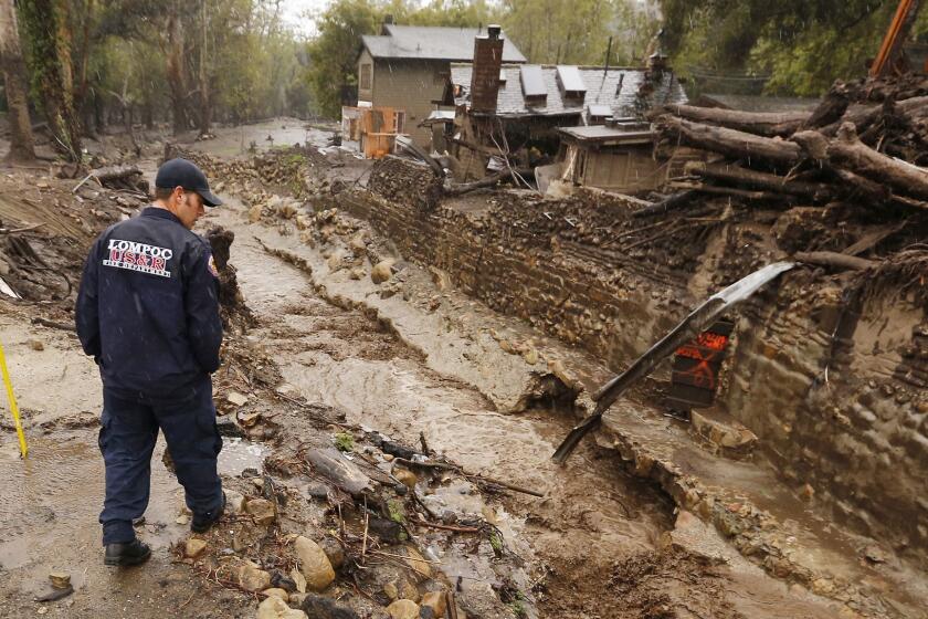 MONTECITO, CA - MARCH 21, 2018 - Lompoc Firefighter Chris Martinez who is with a Search and Rescue Regional Task Force scouts Montecito Creek at the East Valley Road crossing near Parra Grande Lane on Wednesday March 21, 2018 where people lost their lives in the January mud slide. Rain continues to fall in the area. Mandatory evacuations took effect yesterday as people brace for the atmospheric river that forecasters say could be the biggest storm of the season is expected to drench Southern California with potential for mud and debris flows and widespread flooding. (Al Seib / Los Angeles Times)