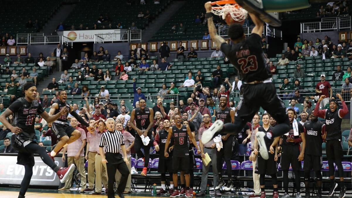 The New Mexico State Aggies bench erupts as Zach Lofton dunks the ball in the final seconds of the semi-final game of the Diamond Head Classic against the Miami Hurricanes.