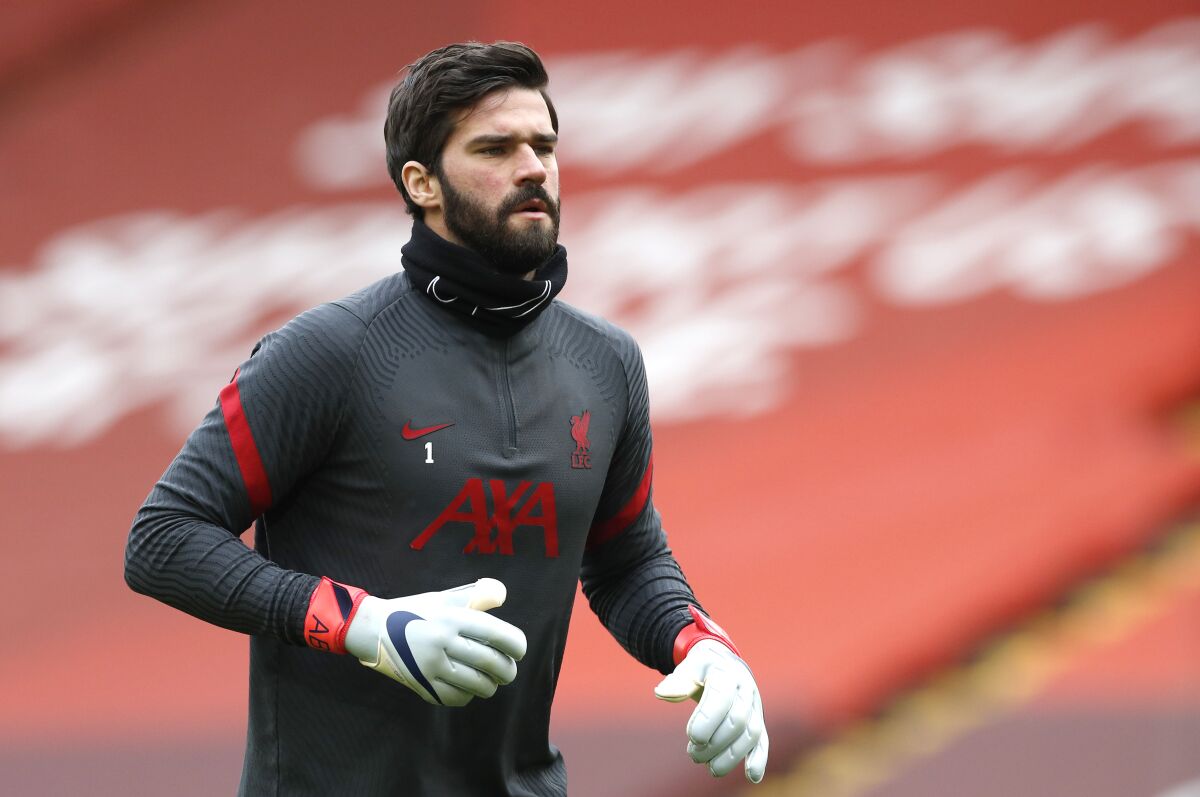 FILE - In this Sunday, March 7, 2021 file photo, Liverpool's goalkeeper Alisson warms up prior to their English Premier League soccer match against Fulham at Anfield stadium in Liverpool, England. Liverpool goalkeeper Alisson Becker signed a long-term contract extension on Wednesday, Aug. 4 the club said. The 28-year-old Brazil keeper's deal follows midfielder Fabinho and right back Trent Alexander-Arnold also extending at Liverpool. (Phil Noble/Pool via AP, file)