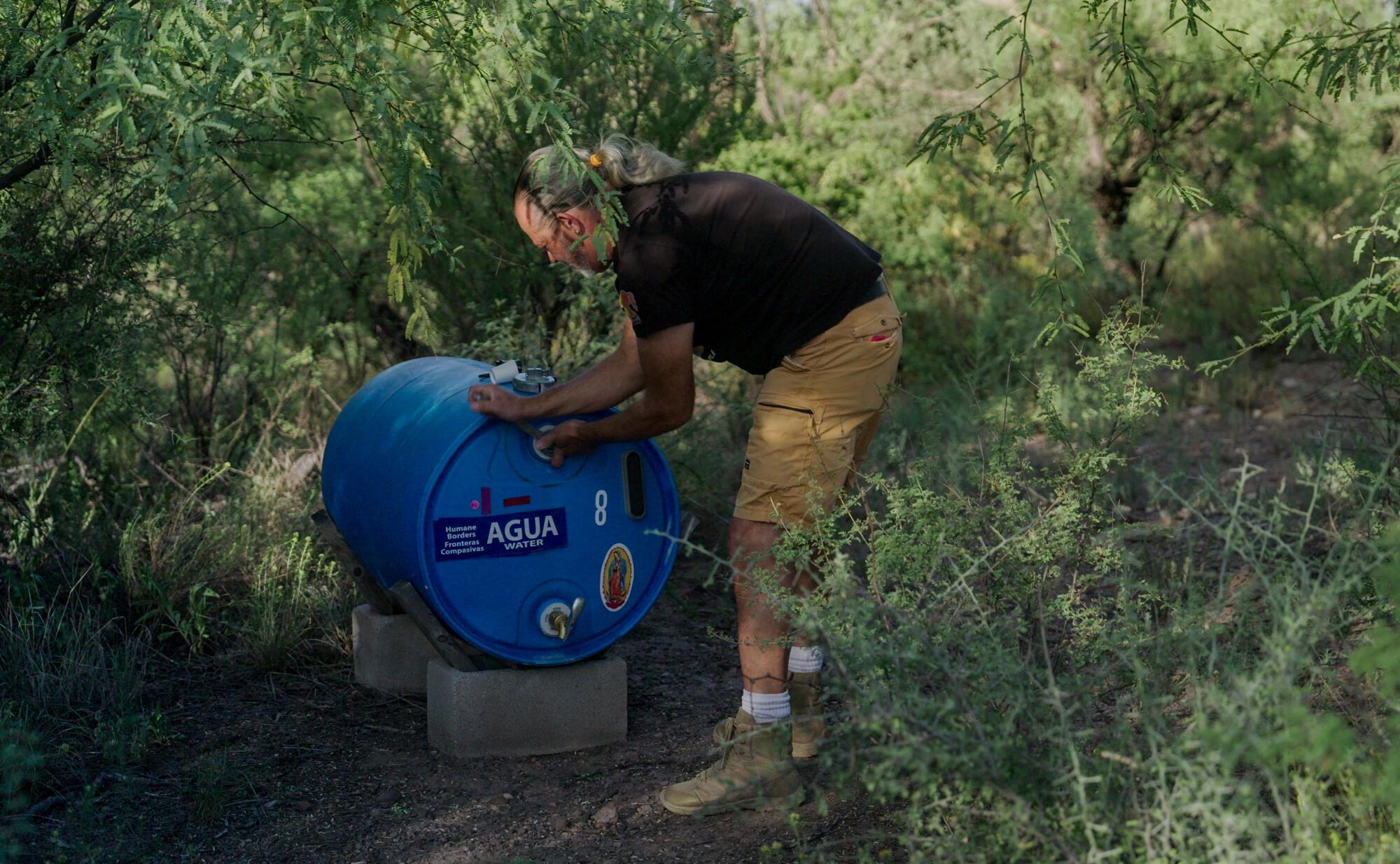 A man checks a water station in the desert south of Tucson
