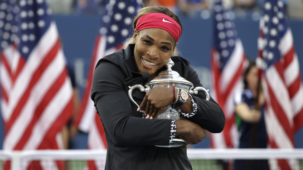 Serena Williams hugs the U.S. Open championship trophy after defeating Caroline Wozniacki on Sunday to win her 18th career Grand Slam.