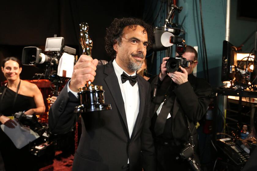 Alejandro Inarritu holds up his director Oscar for "Birdman" backstage.