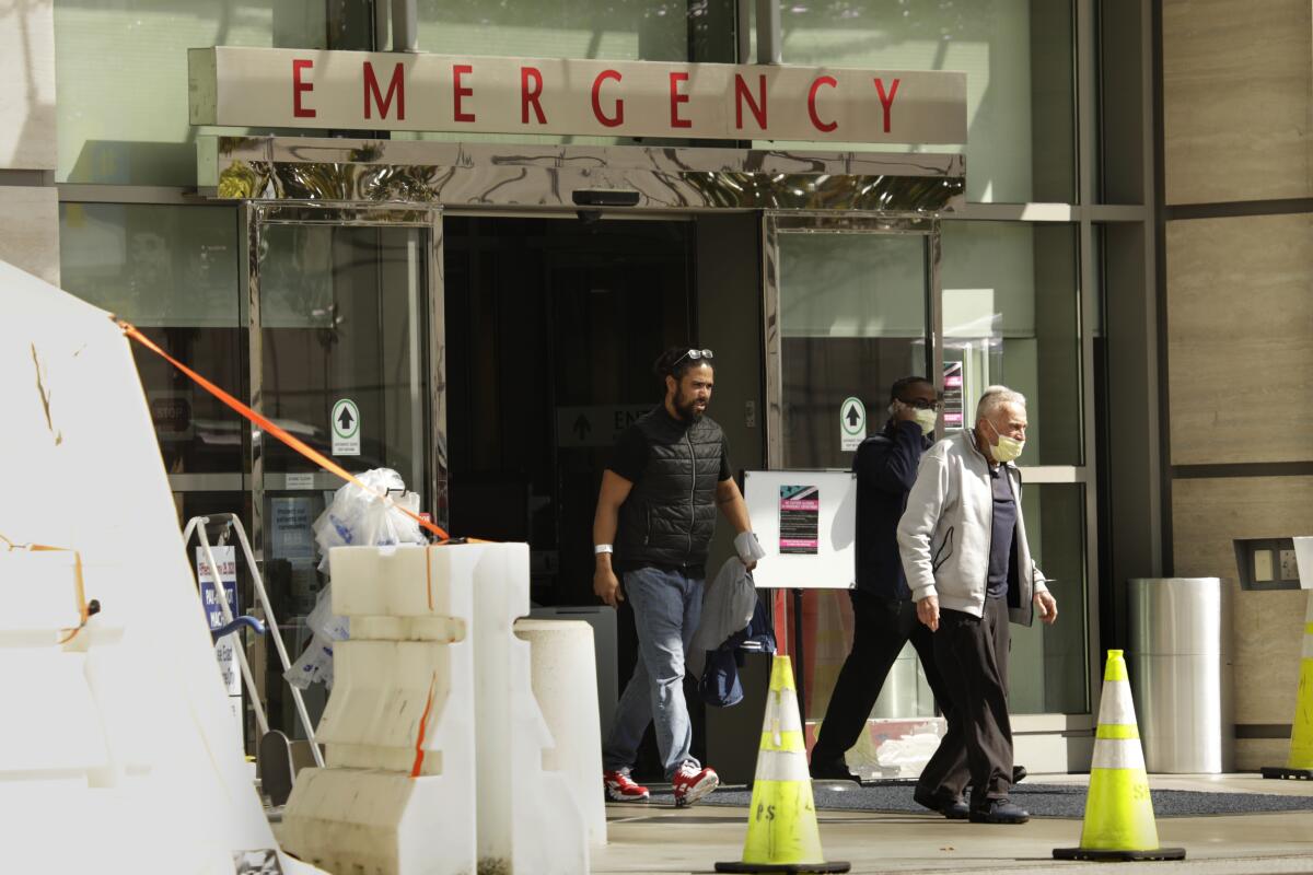 At UCLA Medical Center, a man wearing a mask leaves the emergency room.