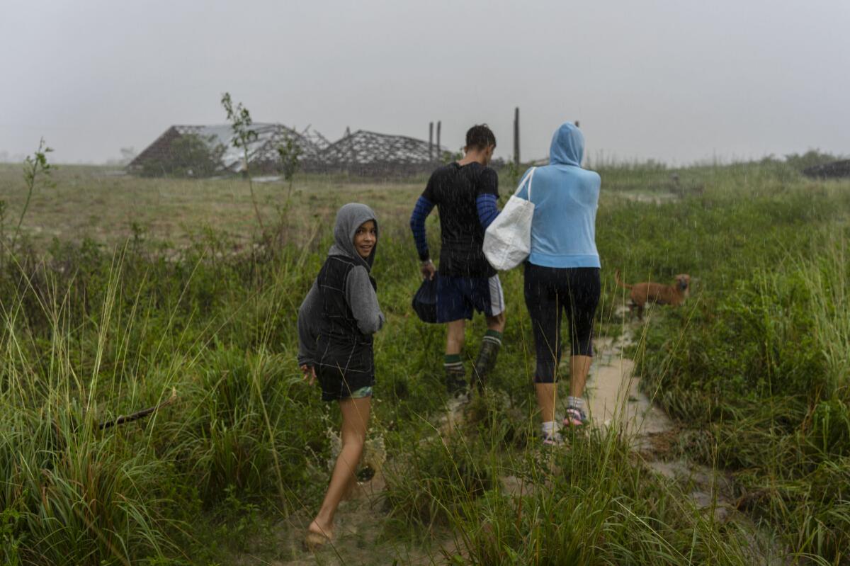 Una familia camina bajo la lluvia en busca de un refugio