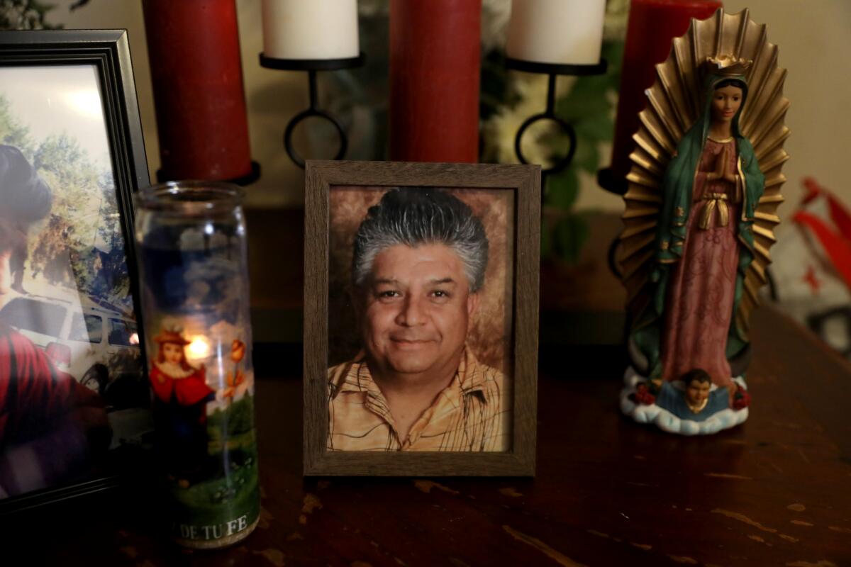 A candle burns next to a framed portrait of the late Jose Zubia