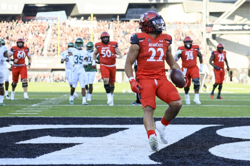 Cincinnati running back Ryan Montgomery carries the ball for a touchdown during the second half of an NCAA college football game against Tulane, Friday, Nov. 25, 2022, in Cincinnati. Tulane won 27-24. (AP Photo/Aaron Doster)