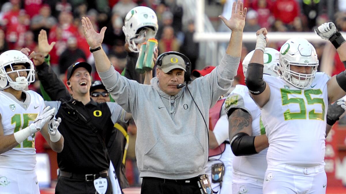 Oregon offensive coordinator Steve Greatwood celebrates along with players and fellow coaches after a review upheld what proved to be the game-winning touchdown against Utah on Saturday.