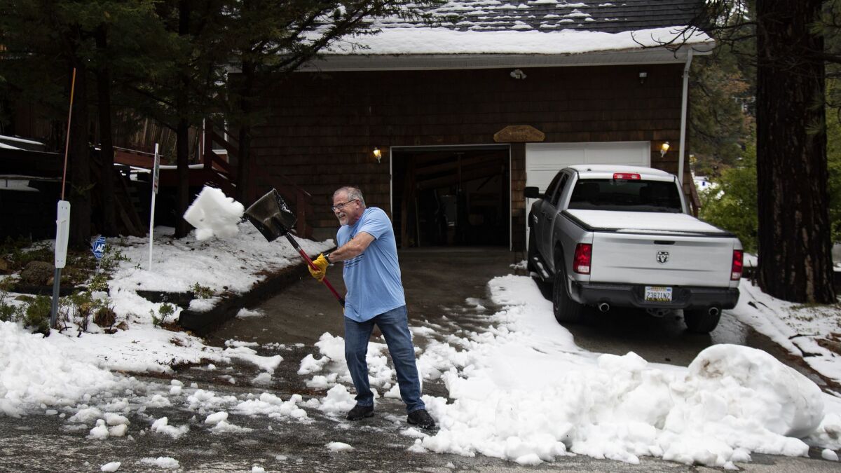 Paul Gill shovels snow at the end of his Running Springs driveway Monday after a late spring snowstorm dropped several inches of snow overnight.
