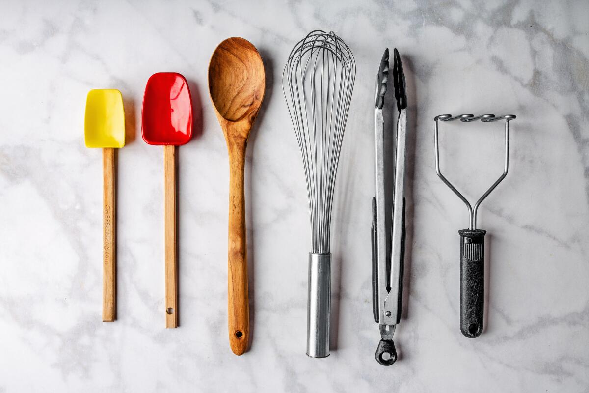 small tools for the kitchen: spatulas, a wooden spoon, whisk, tongs and potato masher