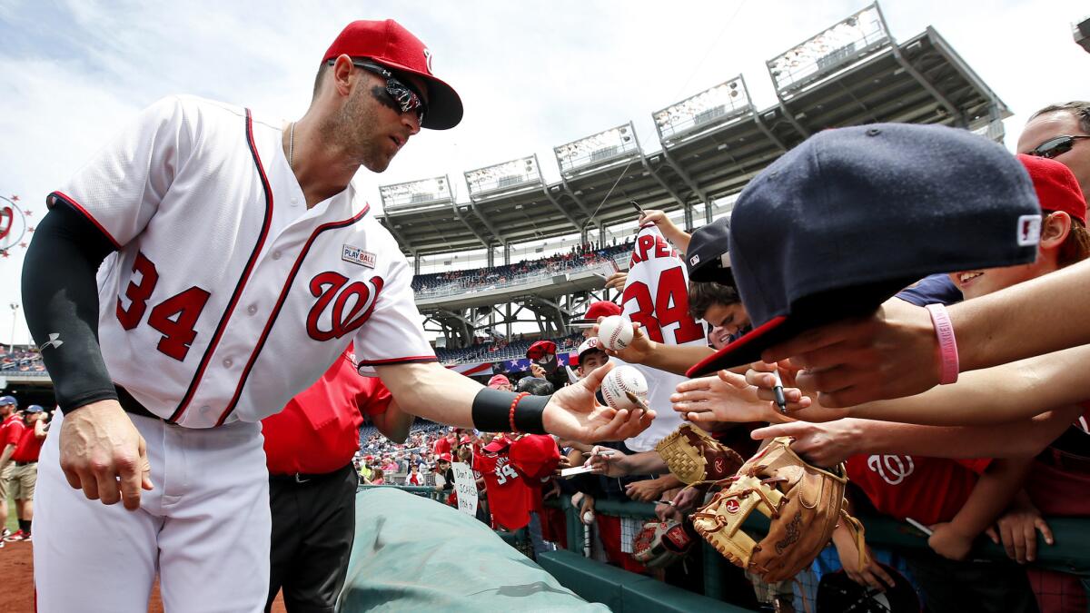 Nationals right fielder Bryce Harper signs autographs Saturday before a doubleheader against the Marlins.