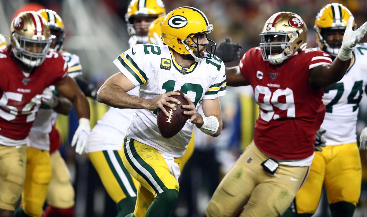 Packers quarterback Aaron Rodgers scrambles from the 49ers pass rush during a game Nov. 24, 2019, at Levi's Stadium in Santa Clara.