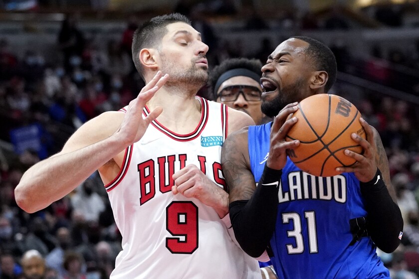 Orlando Magic guard Terrence Ross, right, drives against Chicago Bulls center Nikola Vucevic during the second half of an NBA basketball game in Chicago, Monday, Jan. 3, 2022. (AP Photo/Nam Y. Huh)