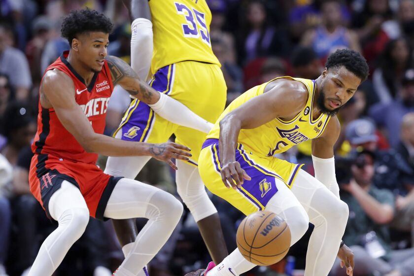 Malik Beasley, derecha, de los Lakers de Los Ángeles, pierde el balón bajo la presión de Jalen Green, izquierda, de los Rockets de Houston, durante la segunda mitad del juego de baloncesto de la NBA el miércoles 15 de marzo de 2023, en Houston. (AP Foto/Michael Wyke)