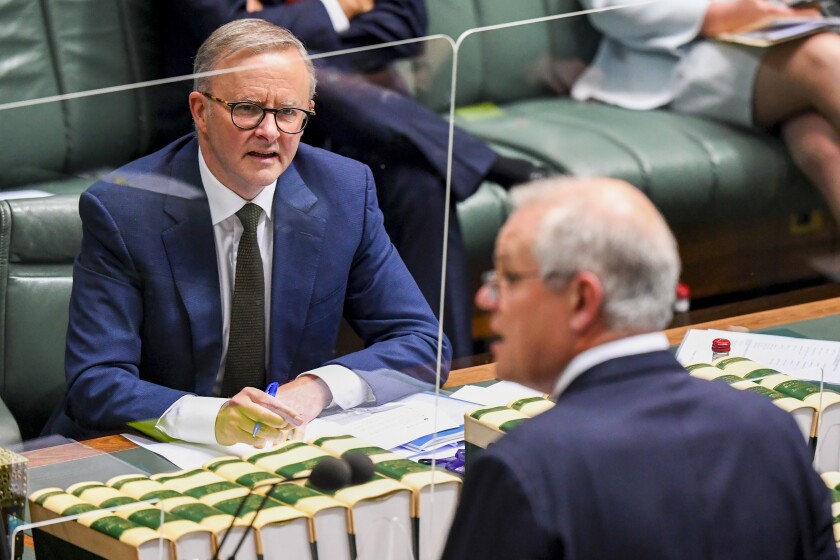 Australian Opposition Leader Anthony Albanese, left, watches as Prime Minister, Scott Morrison speaks during House of Representatives Question Time at Parliament House in Canberra, Thursday, Dec. 2, 2021. Australia's opposition leader says the nation would set a more ambitious target of reducing its greenhouse gas emissions by 43% by the end of the decade if the government changes at elections early next year. (Lukas Coch/AAP Image via AP)