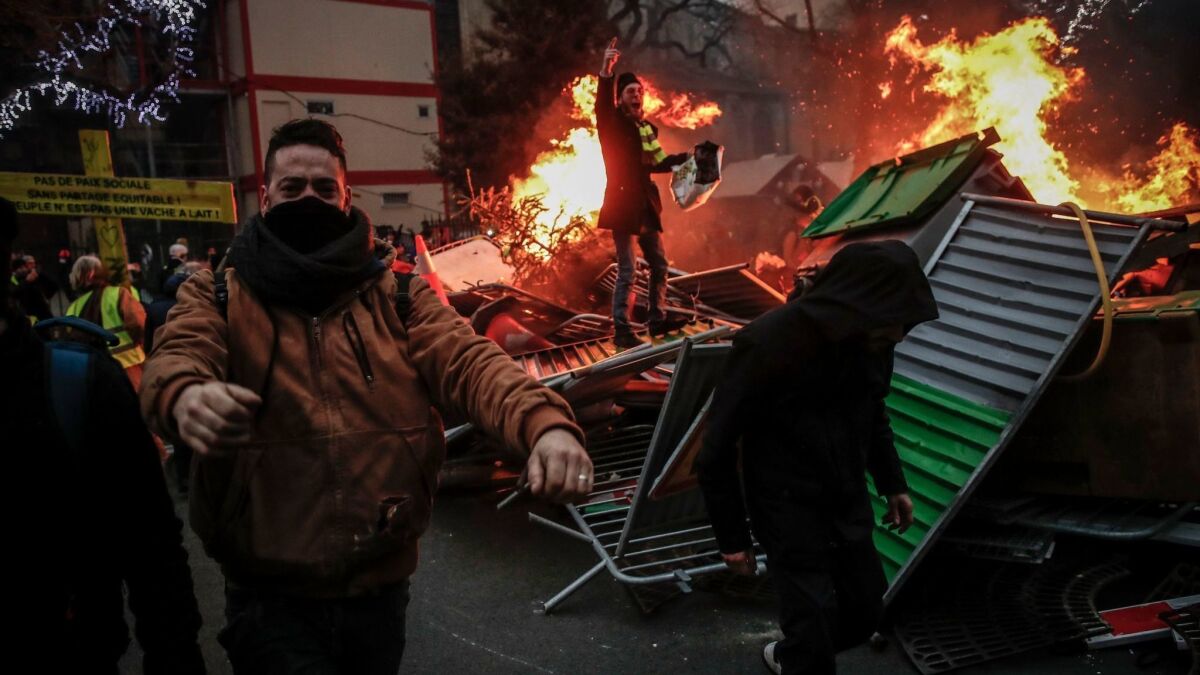Protesters build a barricade they set on fire as clashes erupt between them and the French riot police during a yellow vest protest in Paris on Saturday.